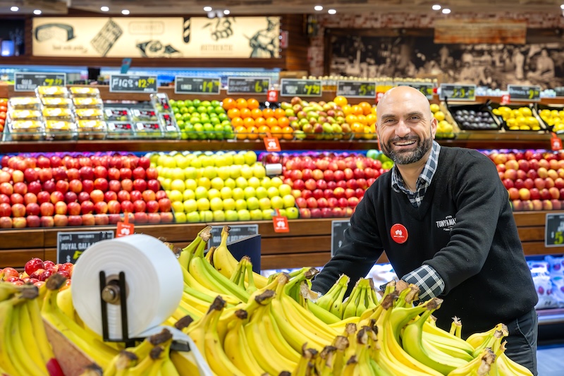 A team member standing in the fruit and vegetable stands at Tony & Marks