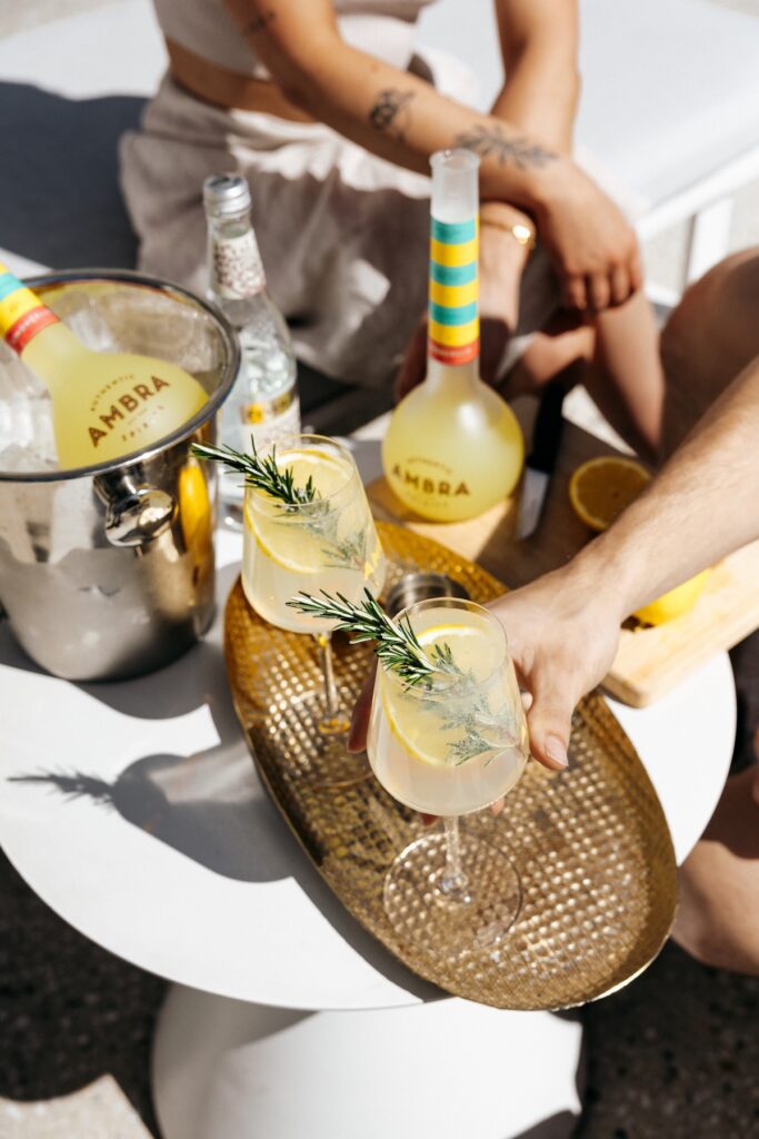 A tray with cocktails, surrounding by Ambra spirits bottles
