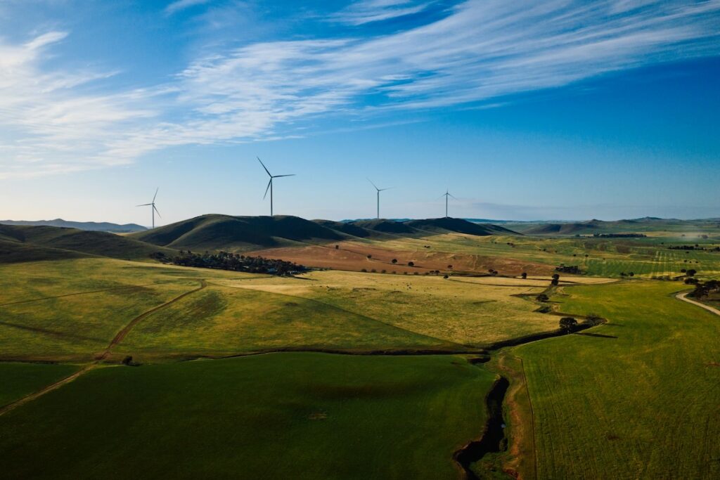 Neon Goyder South Australian wind farm, surrounding by green hills and blue sky