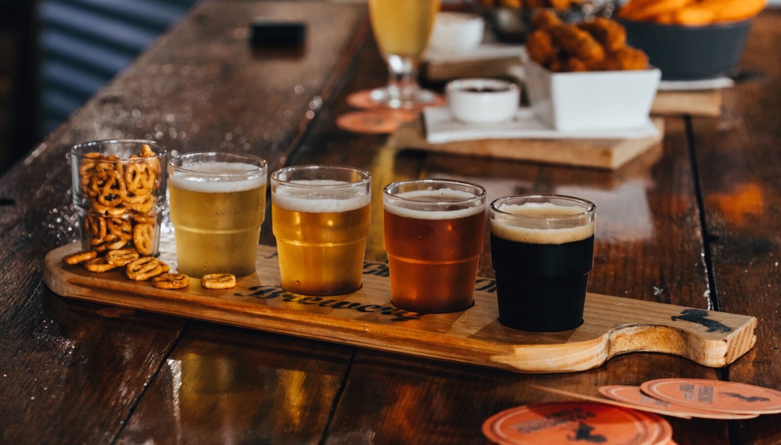 A beer paddle and pretzels on a bar table at Prancing Pony brewery