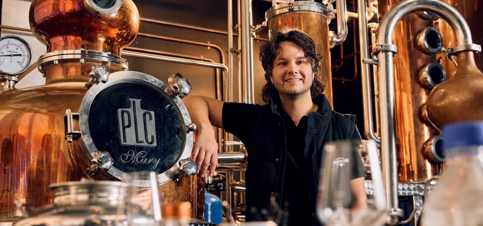 A person standing near the fermentation tanks at Prohibition Liquor Co