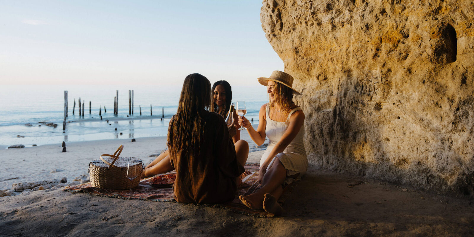 3 people enjoying a picnic on the beach at Port Willunga Beach