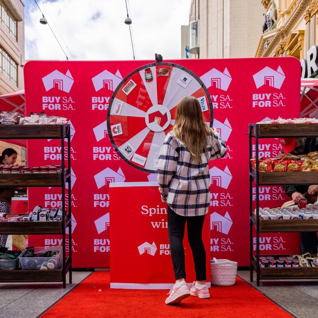 A person spinning a wheel for a Buy SA week competition