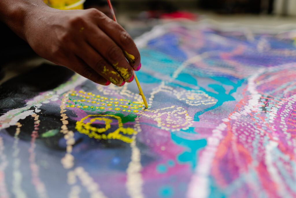 Close up photo of Lisa Khan's hand whilst painting artwork